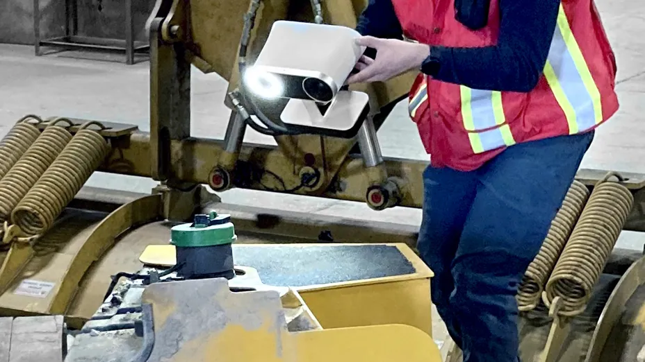 Engineer scanning a heavy equipment attachment with a handheld Artec Leo